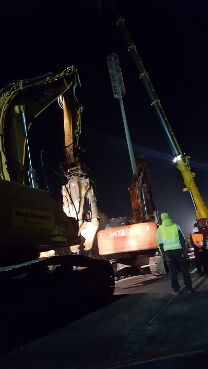 Kran und Bagger halten den Mast, whrend ein weiterer Bagger demontiert